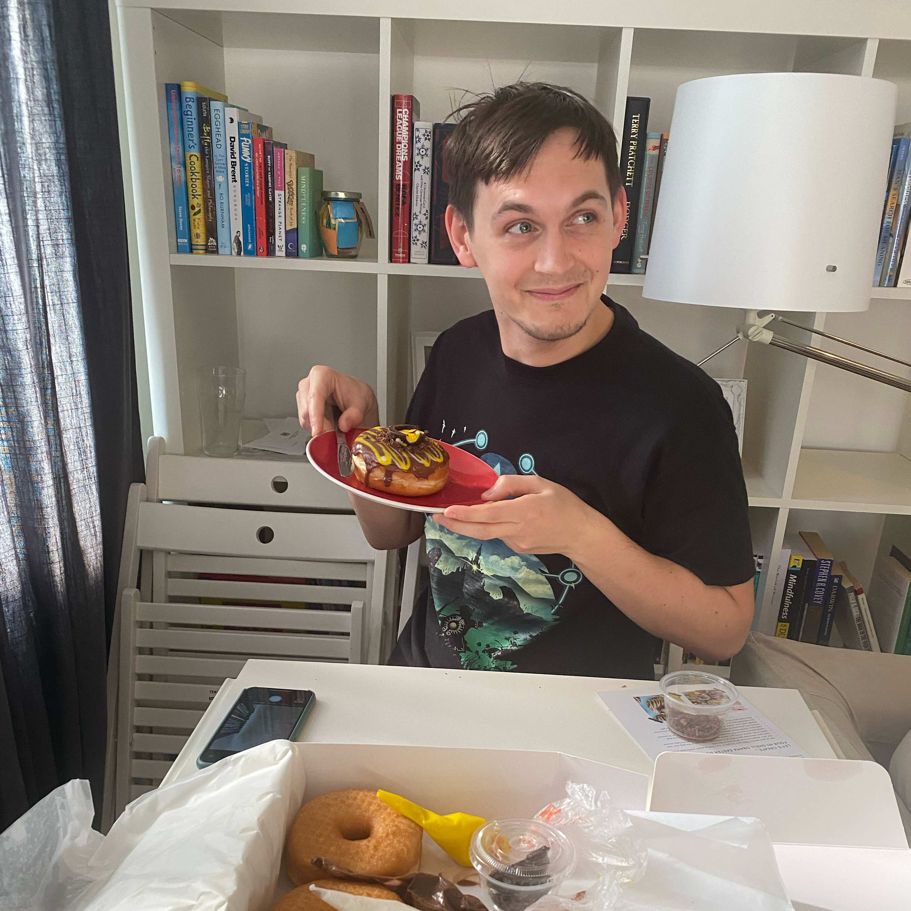 Conor holding a decorated doughnut after moving in together in Tooting Broadway.